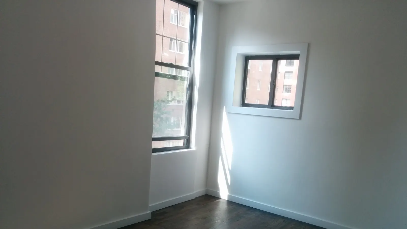 Pièce d'un appartement vide avec parquet et fenêtre, surface privative à mesurer en copropriété